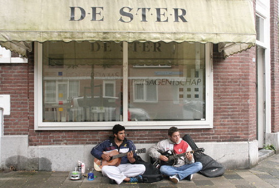 Twee Argentijnse globetrotters, Lucas Micheloud (links) en Augustin Macagno schuilen voor de regen onder de markies van De Ster.