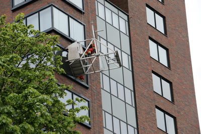 Glazenwassers vast tegen gevel op Admiraliteitskade