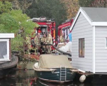 Duikers dichten lekkage in zinkende woonboot aan Crooswijksebocht